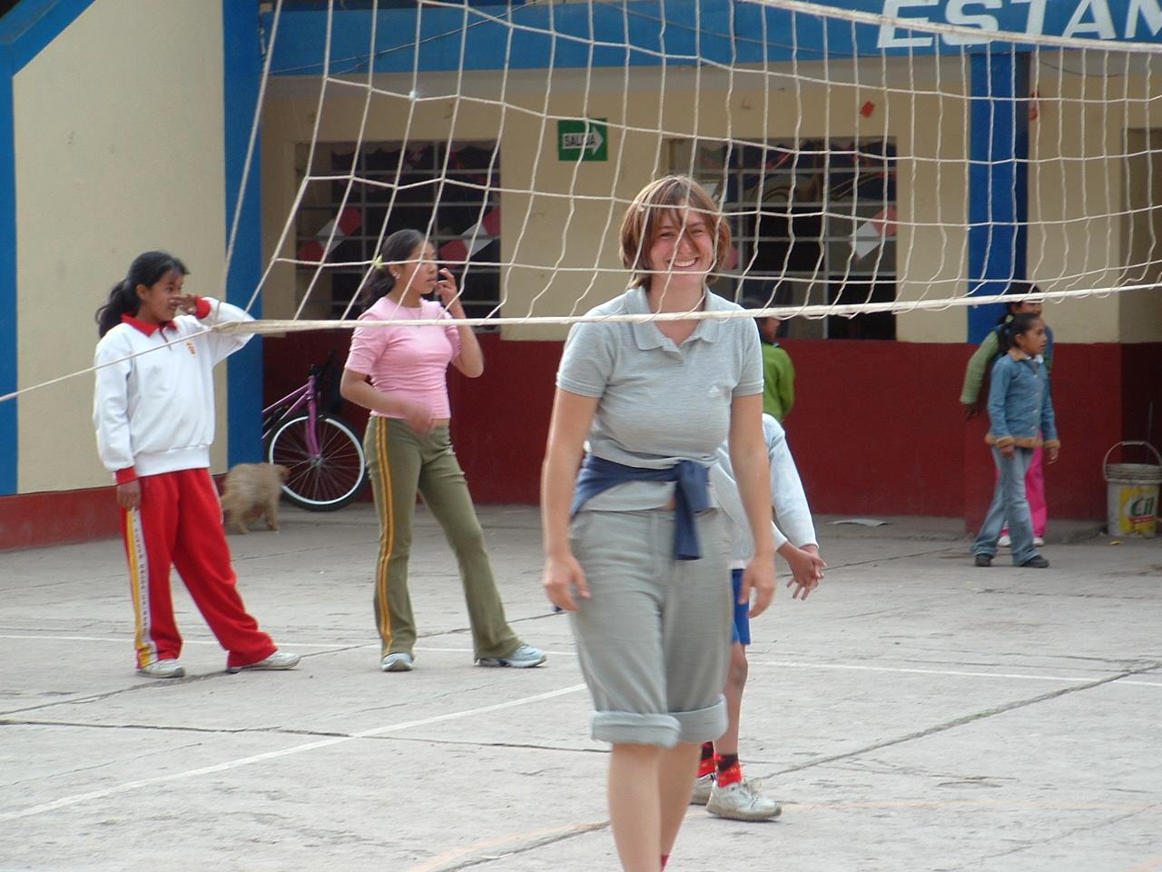 Voluntaria participando en el juego de voleibol que organizó en su voluntariado deportivo. Instructora de voleibol participando en su voluntariado como profesor de deportes en Perú.